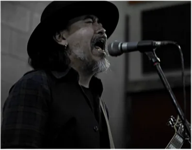 Carlos Gonzalez cantando e tocando guitarra
